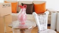 Moving scene with an approach to a chair, a vase on a table packed in plastic inside a room with a sofa, plastic rolls and