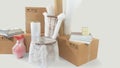 Moving scene with a chair and vase packed in plastic bubble with closed cardboard boxes, books and rolls of plastic and foam to