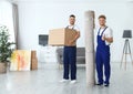 Moving service employees with box and carpet