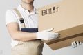 Moving service worker holds cardboard box close-up. Mover in uniform holding parcel in hands. Relocation services man Royalty Free Stock Photo