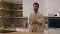 Moving shot adult Caucasian man in glasses at home modern kitchen posing hands crossed smiling to camera. Portrait 40s