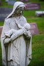 Mother cradling dead baby stone cemetery statue