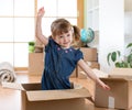 Moving to new apartment. Happy child in cardboard box. Royalty Free Stock Photo