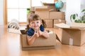 Moving to new apartment. Happy child in cardboard box. Royalty Free Stock Photo