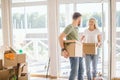 Happy Couple Carrying Cardboard Boxes Into New Home On Moving Day