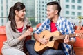 After moving together young man plays love song for his girlfrie