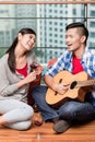 After moving together young man plays love song for his girlfrie