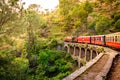 moving Toy train on arch bridge over mountain slopes of Shimla to Kalka Royalty Free Stock Photo