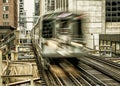 Moving Train on elevated tracks within buildings at the Loop, Glass and Steel bridge between buildings - Chicago City Center Royalty Free Stock Photo