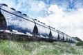 Moving train with grain wagons on the background of the blue sky