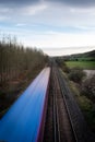 A moving train on straight tracks in the English Countryside Royalty Free Stock Photo