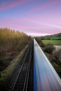 A moving train on straight tracks in the English Countryside Royalty Free Stock Photo