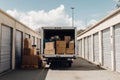A moving truck loaded with boxes parked between storage units Royalty Free Stock Photo