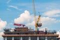 Moving yellow tower crane and unfinished building construction against blue sky Royalty Free Stock Photo