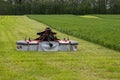 Mower conditioner on a partially mown pasture Royalty Free Stock Photo