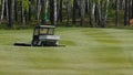 Mower work in the grass at the edge of a Scottish golf course. Machine for turf on Golf Royalty Free Stock Photo