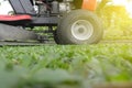 Mowing or cutting the long grass with a green lawn mower with bu Royalty Free Stock Photo