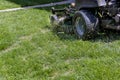 Mowing cutting the long grass with a green lawn mower Royalty Free Stock Photo