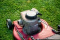 Mowing a lawn with a old style petrol gasoline lawnmower. Red lawn mower cutting grass . Gardening concept background Royalty Free Stock Photo