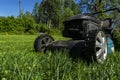 Mowing lawns, Lawn mower on green grass, mower grass equipment, mowing gardener care work tool, close up view, sunny day. Soft lig Royalty Free Stock Photo