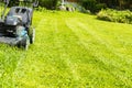Mowing lawns, Lawn mower on green grass, mower grass equipment, mowing gardener care work tool, close up view, sunny day. Royalty Free Stock Photo