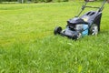 Mowing lawns. Lawn mower on green grass. mower grass equipment. mowing gardener care work tool close up view sunny day Royalty Free Stock Photo