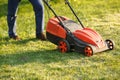 Mowing trimmer - worker cutting grass in green yard at sunset. Man with electric lawnmower, lawn mowing. Gardener Royalty Free Stock Photo