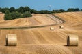 Mown cornfield with big round hay bales - with a trail in the background