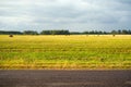 Mown wheat field with bales of straw against a blue sky on a summer day at sunset. Agriculture Royalty Free Stock Photo