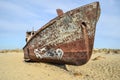 Rusty boat with a graffiti n the former bed of the Aral Sea