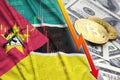 Mozambique flag and cryptocurrency falling trend with two bitcoins on dollar bills