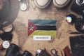 Mozambique Flag Between Traveler`s Accessories on Old Vintage Map. Overhead Shot