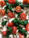 Mozzarella, spinach, mushroom and tomato topped pizza