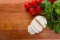 Mozzarella tomatoes and basil on a wooden rustic background Royalty Free Stock Photo