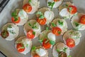 Mozzarella and tomatoes with thyme, arugula and Basil are on corn chips. Preparation of canapes. Close up. The view from the top Royalty Free Stock Photo