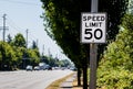 50 mph speed limit sign on post with a road and tree Royalty Free Stock Photo