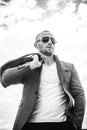 Mr. Perfection. Close-up of handsome young man wearing suit jacket, sunglasses and looking away while standing against Royalty Free Stock Photo