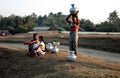 A burmese woman putting jars full of water on her head