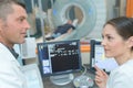 mri machine and screens with doctor and nurse