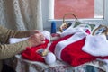 Mrs. Claus sewing the Santa suit for Christmas. Concept of Christmas