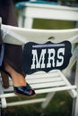 Mrs. leg stands on a decorative chair with a sign with an inscription.