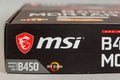 MSI B450 MORTAL MAX motherboard against a gray background. Black box with the new computer hardware. Modern digital technology.