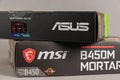 MSI B450 MORTAL MAX motherboard and ASUS GFORCE GTX 1650 graphics card against gray background. Boxs with the new computer Royalty Free Stock Photo