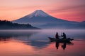 Mt Fuji at Kawaguchiko lake in Japan at sunrise, Mt. Fuji or Fujisan with Silhouette three fishing people on boats and mist at Royalty Free Stock Photo