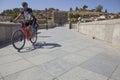 MTB biker crossing Saint Martin medieval bridge, Toledo, Spain