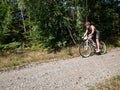 Mtb rider in black jersey hold brakes in front of right turn into forest