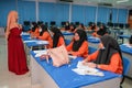 Muslim teacher smiling to her student who answer the question