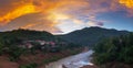 Muang Khua village in the mountains of North Laos, sunset dramatic sky. Small laotian village in river valley. Travel destination Royalty Free Stock Photo