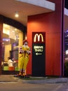 A Ronald McDonald statue, mascot standing in front of the McDonald`s drive THRU, greeting guests with the traditional Thai wai
