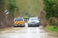 Two cars driving through a flooded road. Hertfordshire. UK